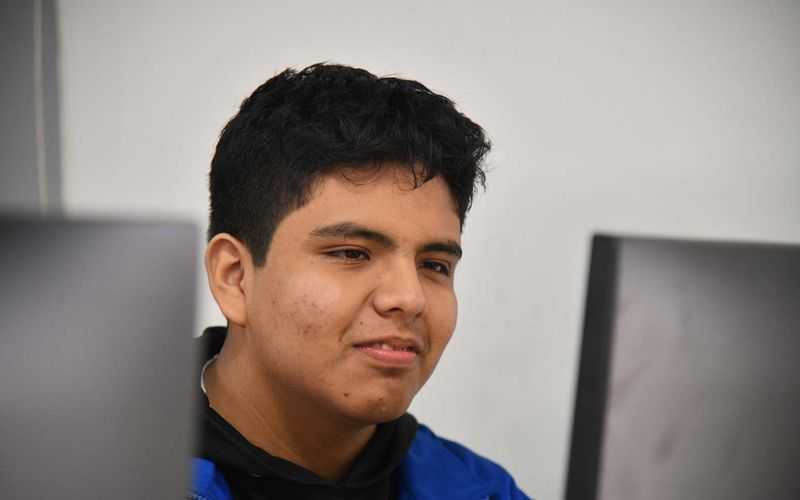 Estudiante de secundaria concentrado frente a la computadora