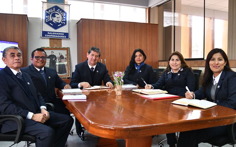 Equipo de gestión reunido alrededor de una mesa de madera en la sala de reuniones