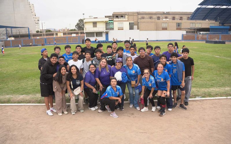 Padres de familia e hijos posando juntos en la cancha después del campeonato