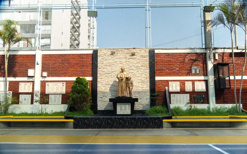 Monumento a Don Bosco en el patio de un colegio salesiano