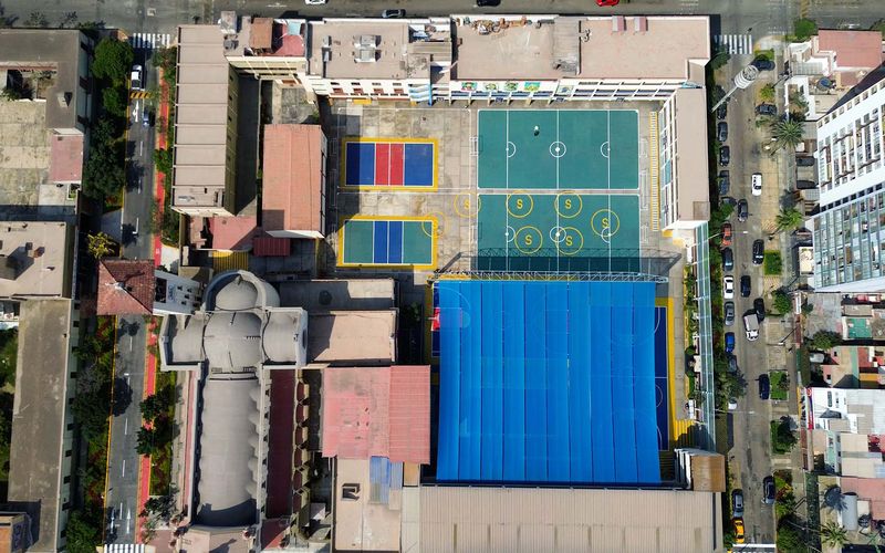 Vista aérea del colegio con el coliseo y el patio techado azul