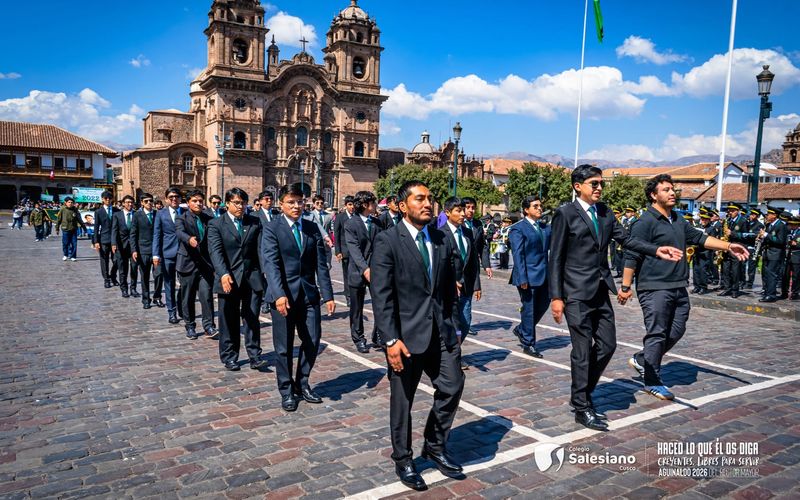 Alumnos en formación desfilando por la Plaza de Armas del Cusco frente a la iglesia de la Compañía
