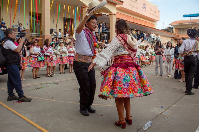 Una pareja baila con trajes folclóricos coloridos en plena calle